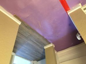 A room with a purple ceiling and a red stripe on the ceiling.