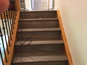 A person is standing on a set of stairs in a house.