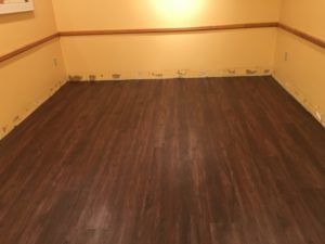 A room with a wooden floor and yellow walls.