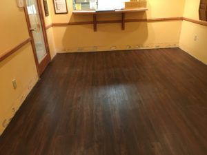 A room with a wooden floor and yellow walls.