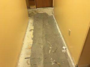 A hallway with a piece of carpet on the floor.