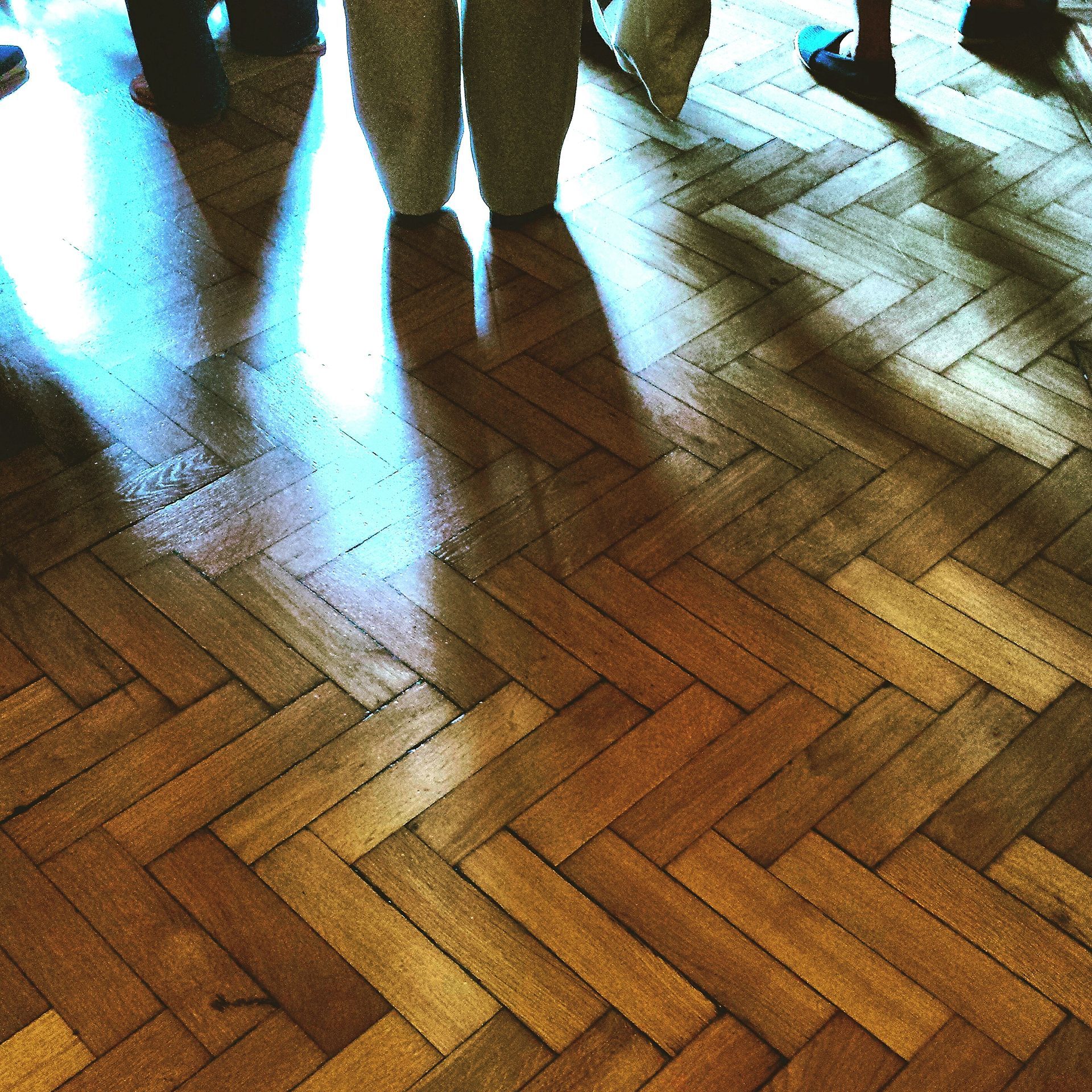 A group of people standing on a wooden floor