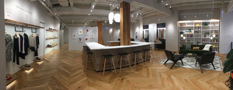 A large room with wooden floors and a bar in the middle of it.