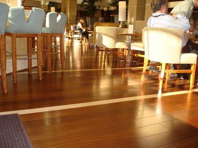 A man sits at a table in a restaurant surrounded by chairs