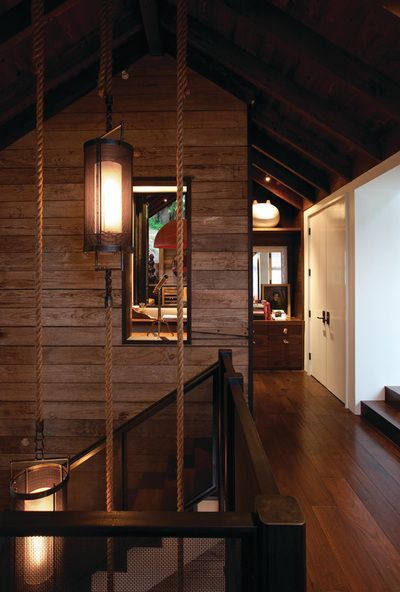 A staircase in a house with a lantern hanging from the ceiling