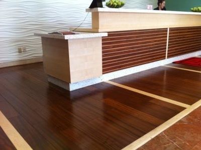 A reception desk in a hotel with a wooden floor