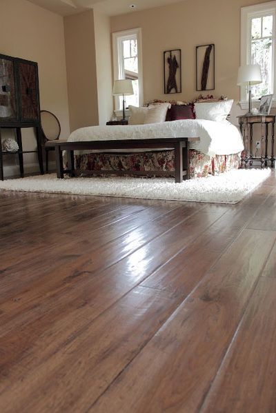 A bedroom with hardwood floors and a large bed