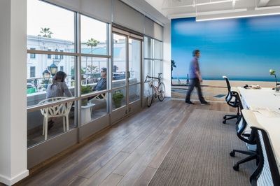 A group of people are sitting at a table in a room with a large window.
