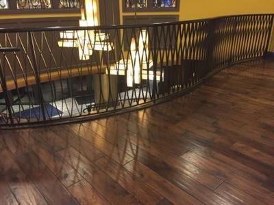 A staircase with a wrought iron railing and a wooden floor.