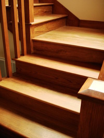 A close up of a wooden staircase with a railing
