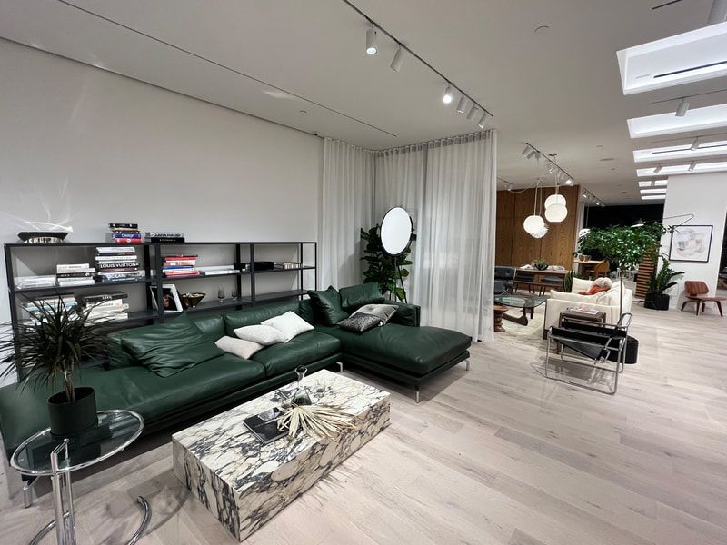 A living room with a green couch and a white coffee table.