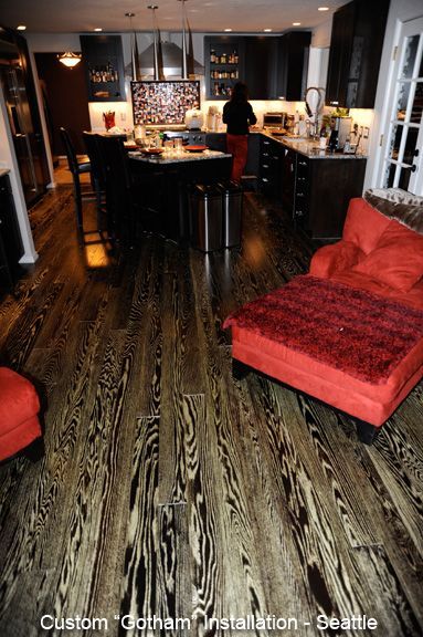 A kitchen with black cabinets and a red chair