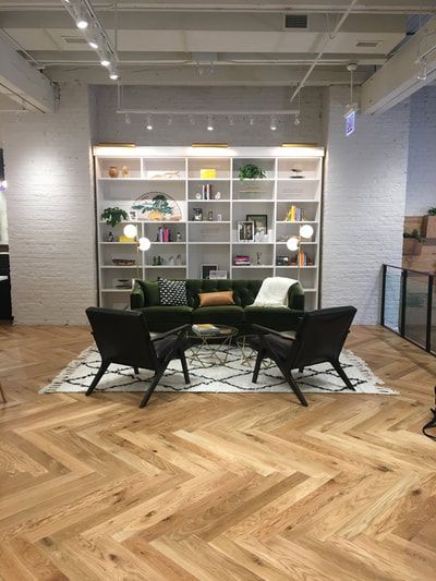 A living room with a couch , chairs , and a bookshelf.