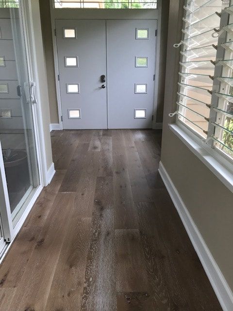 A hallway with hardwood floors and a white door