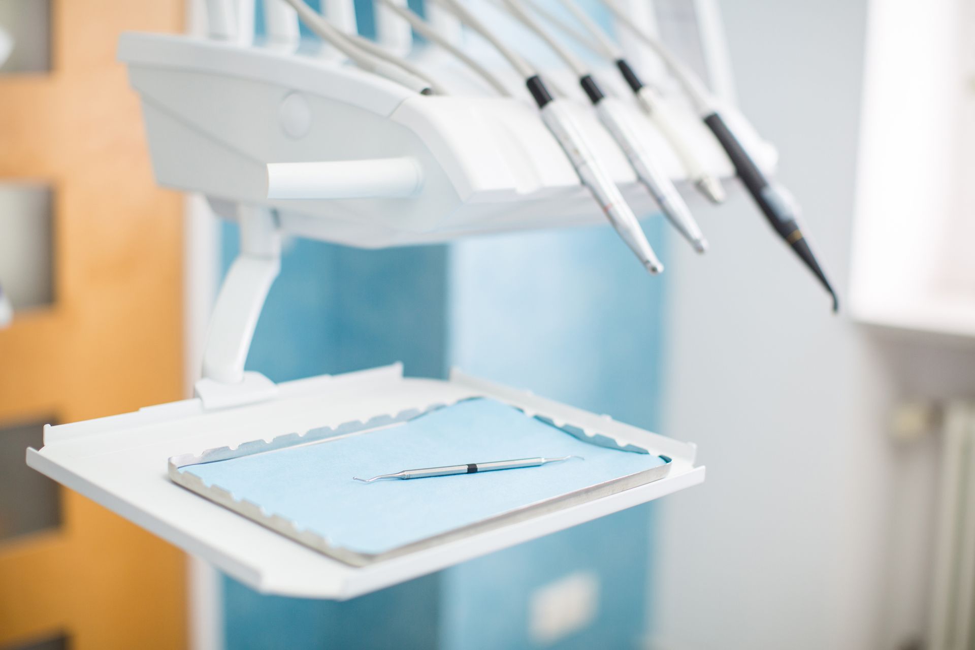 Una poltrona odontoiatrica con sopra un vassoio di strumenti odontoiatrici.