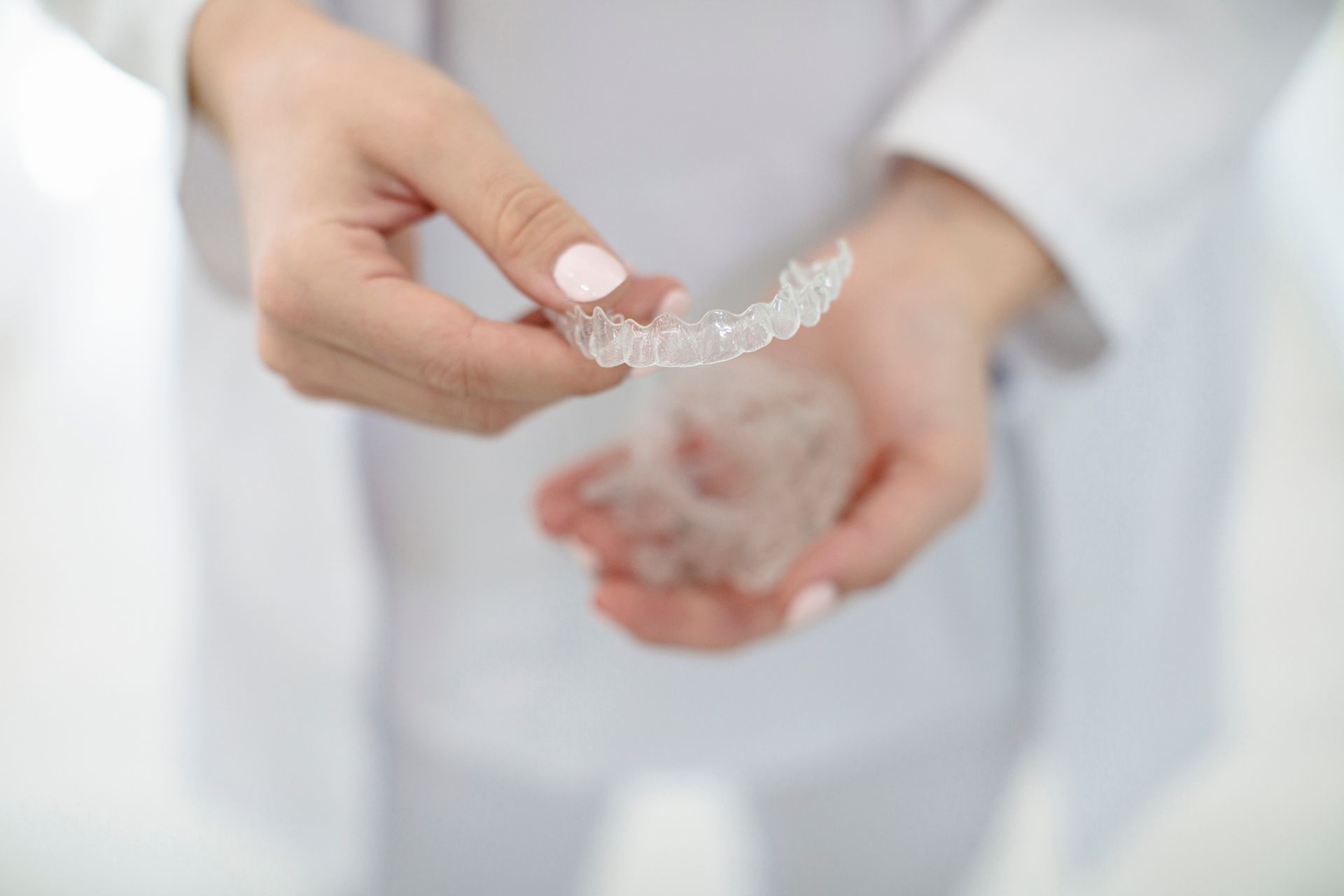 Una donna tiene in mano un tutore trasparente.