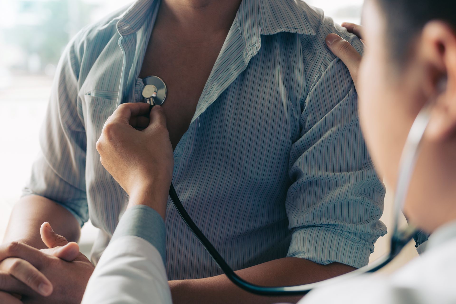 Doctor listening to patient's chest with a stethoscope.