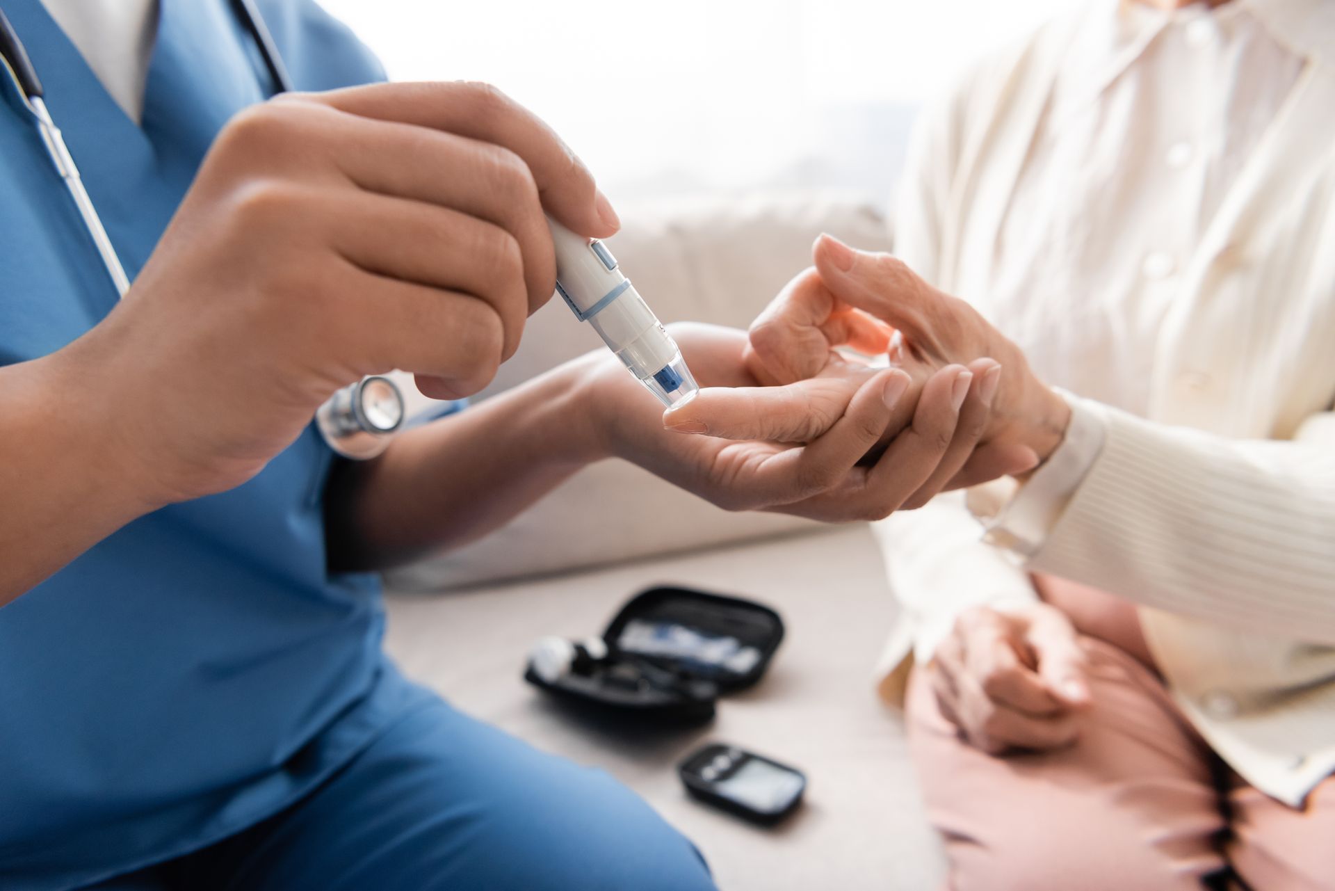 Nurse testing a patient's blood sugar with a lancet device. 