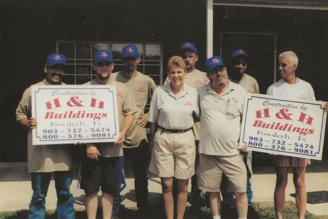 A group of people holding signs that say H&H buildings.