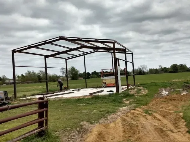 A metal structure is being built in the middle of a field.