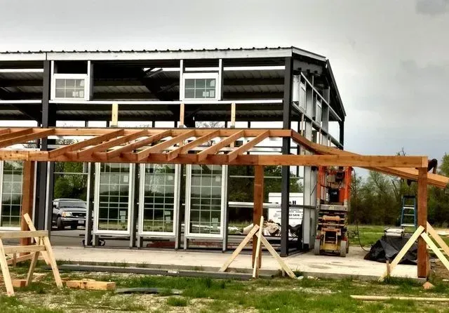 A building under construction with a wooden structure in front of it.