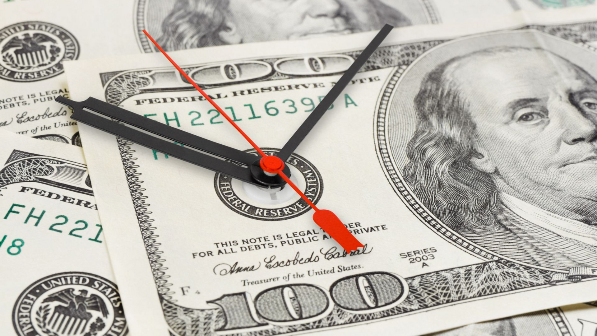 Couple walking, hugging, with suitcase outside building.