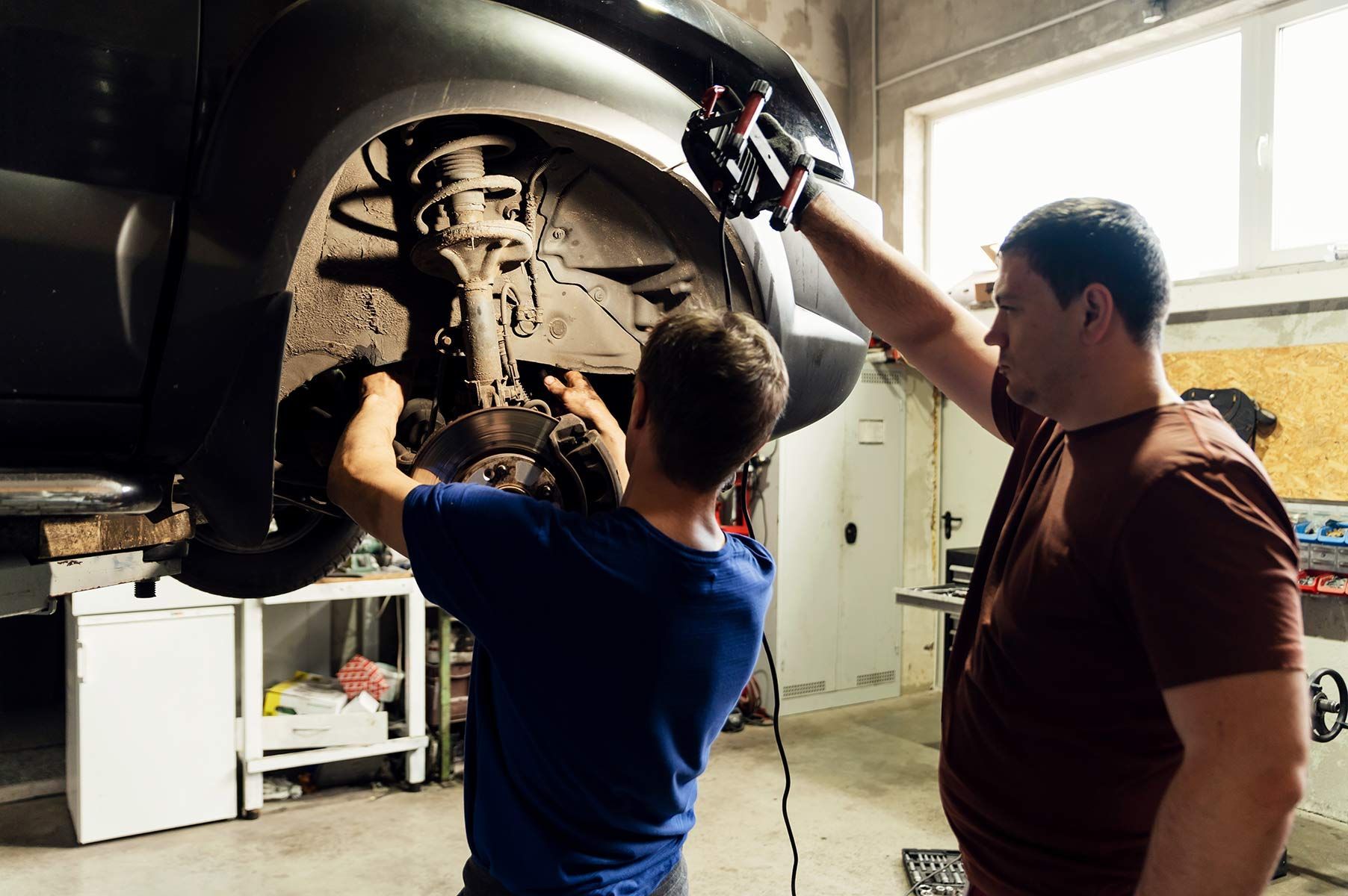 Two Men Are Working On A Car In A Garage — Fase Automotive In Sunset, QLD
