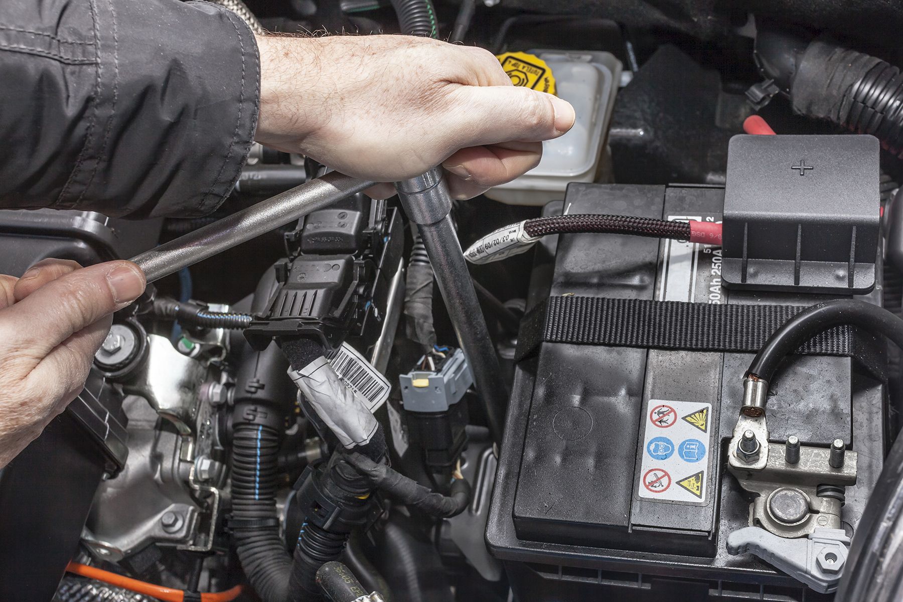 A Person Is Working On A Car Battery With A Wrench — Fase Automotive In Sunset, QLD