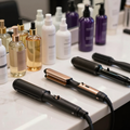 Hair styling tools and various bottled salon hair products arranged on a white counter.