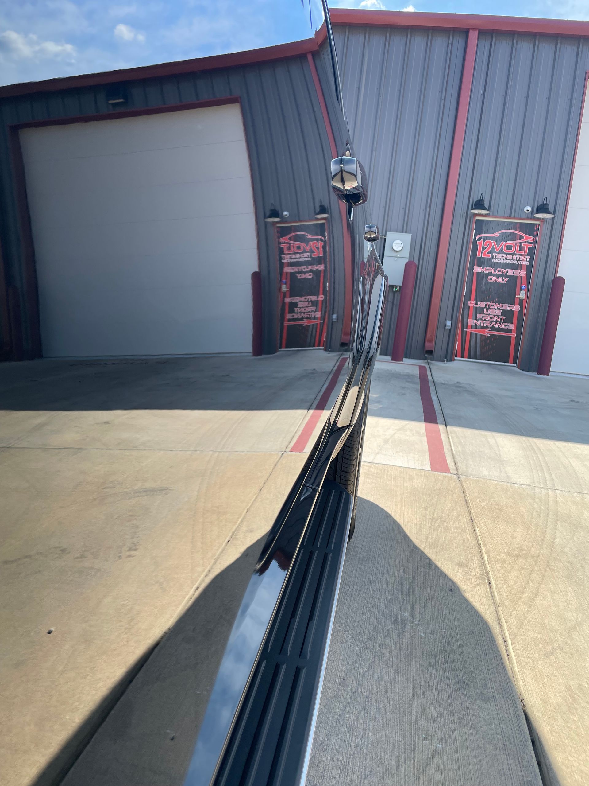 A car is parked in a parking lot in front of a building.