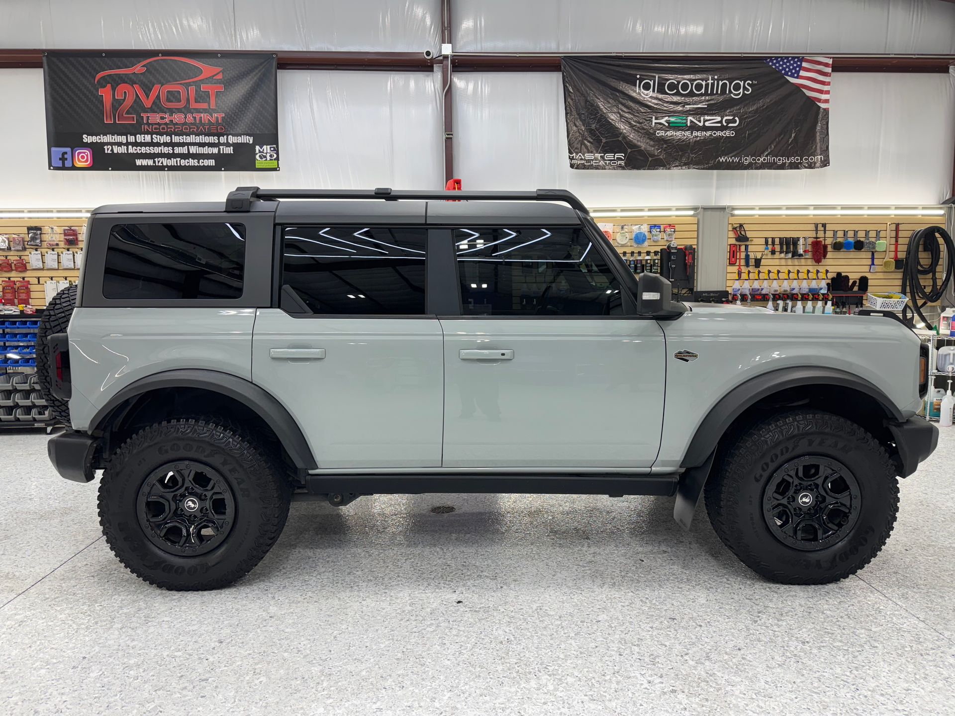 A gray ford bronco is parked in a garage.