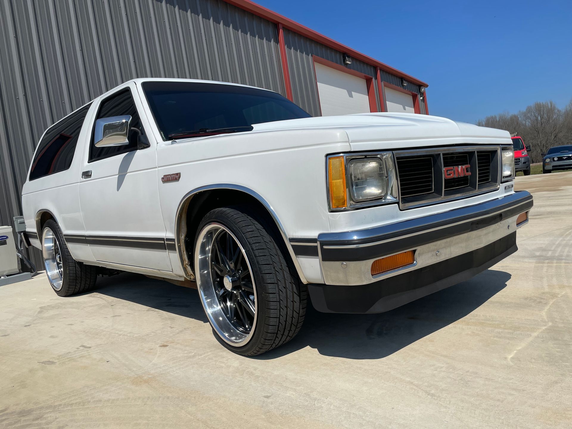 A white gmc sierra is parked in front of a building.
