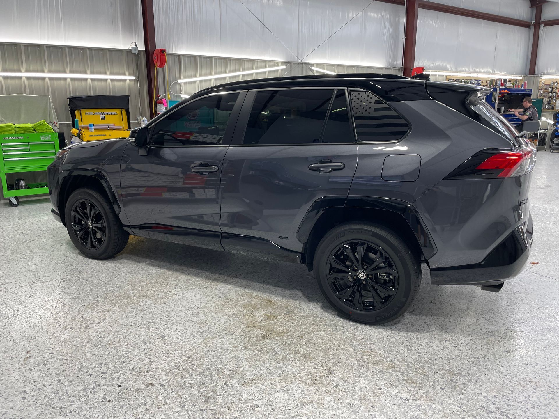 A gray toyota rav4 is parked in a garage.