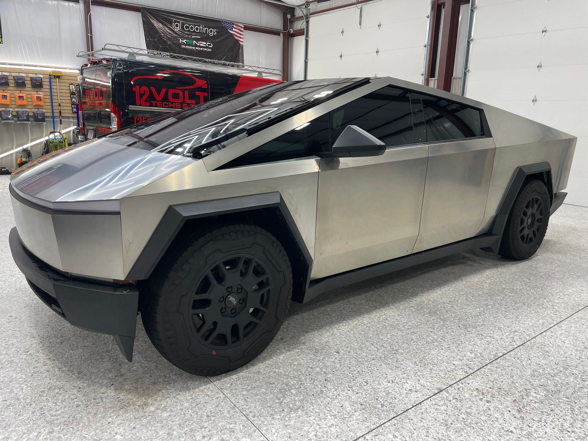 A silver tesla cybertruck is parked in a garage.