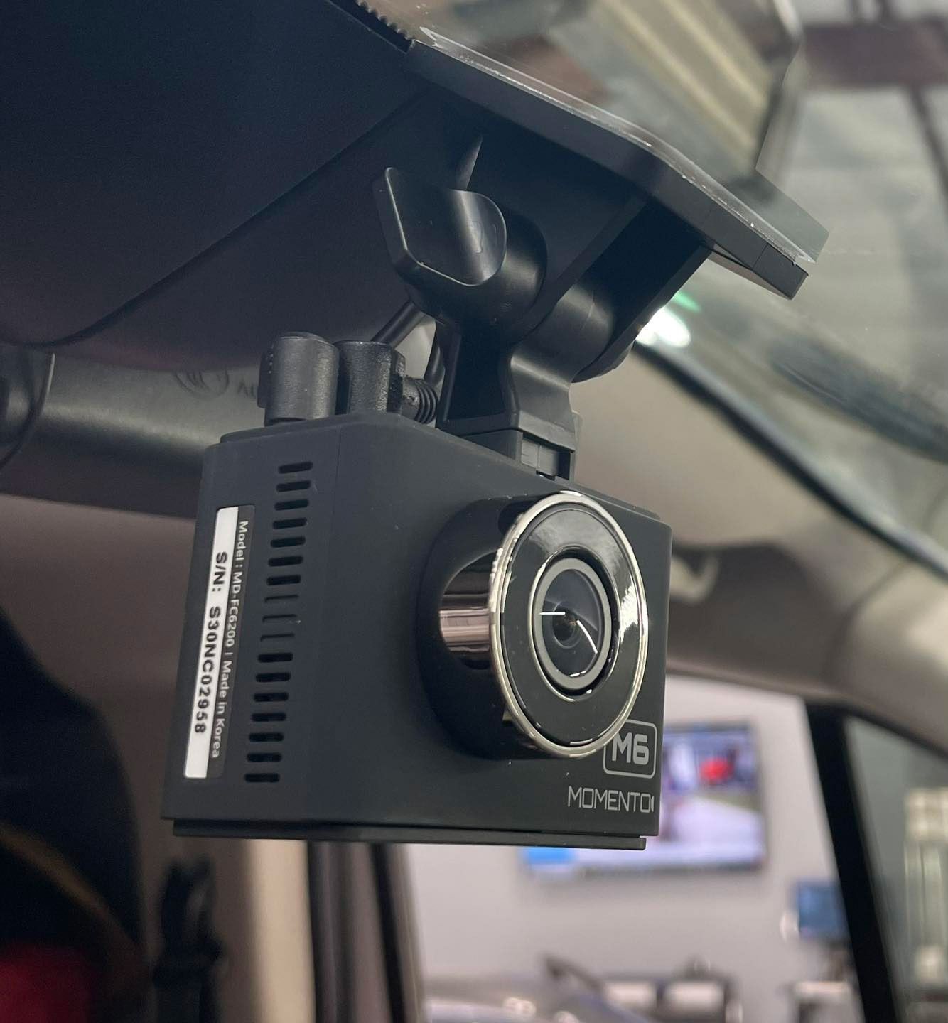 A m6 hcvent dash cam is mounted to the rear view mirror of a car