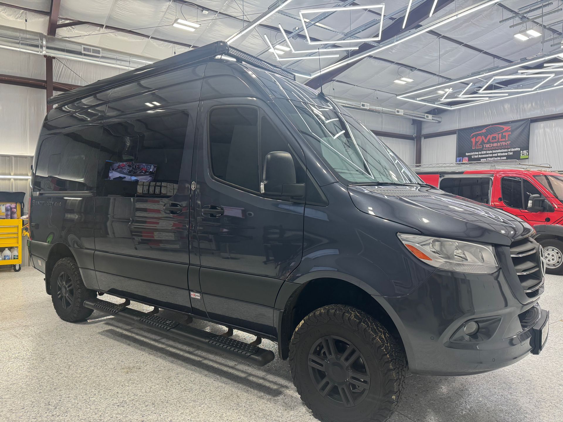 A black van is parked in a garage.