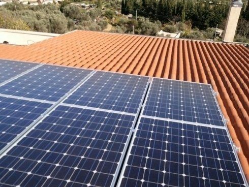 Pannelli solari installati su un tetto di tegole rosse, che catturano la luce solare.