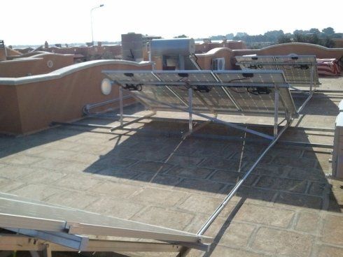 Pannelli solari su un tetto, orientati verso il sole, con struttura metallica di supporto.