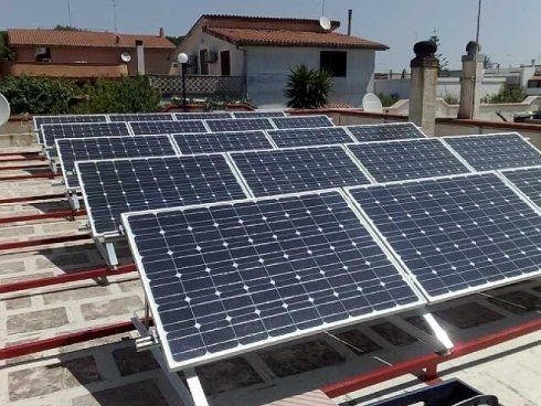 Pannelli solari su un tetto, orientati verso il sole, che catturano l'energia solare.