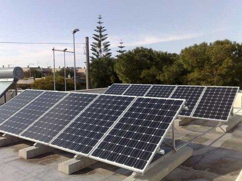 Pannelli solari su un tetto piano, orientati verso il sole, in un ambiente esterno luminoso.