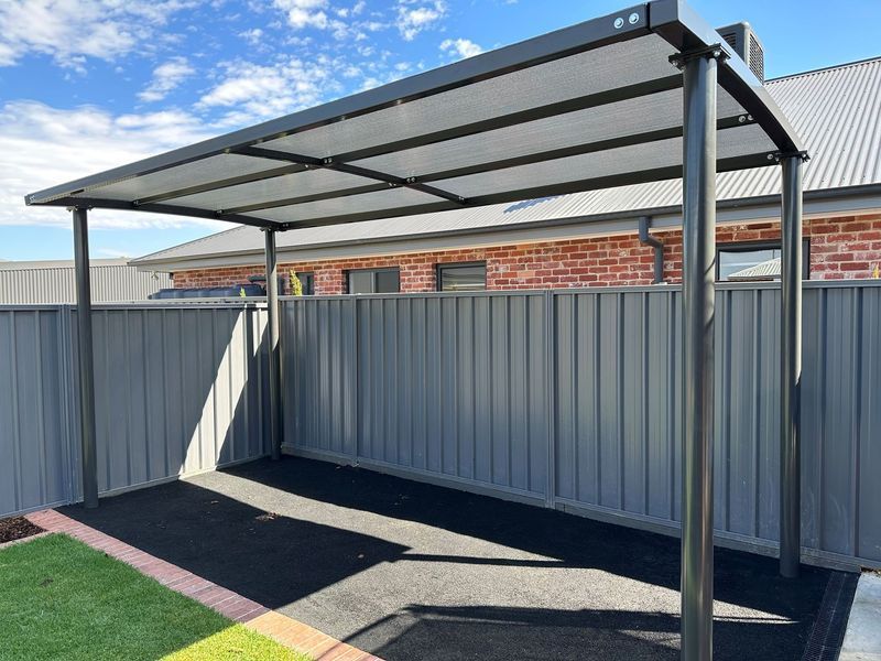 Dark Gray Carport Attached to a Gray Fence — The Gazebo and Shade Centre in Jindera, NSW