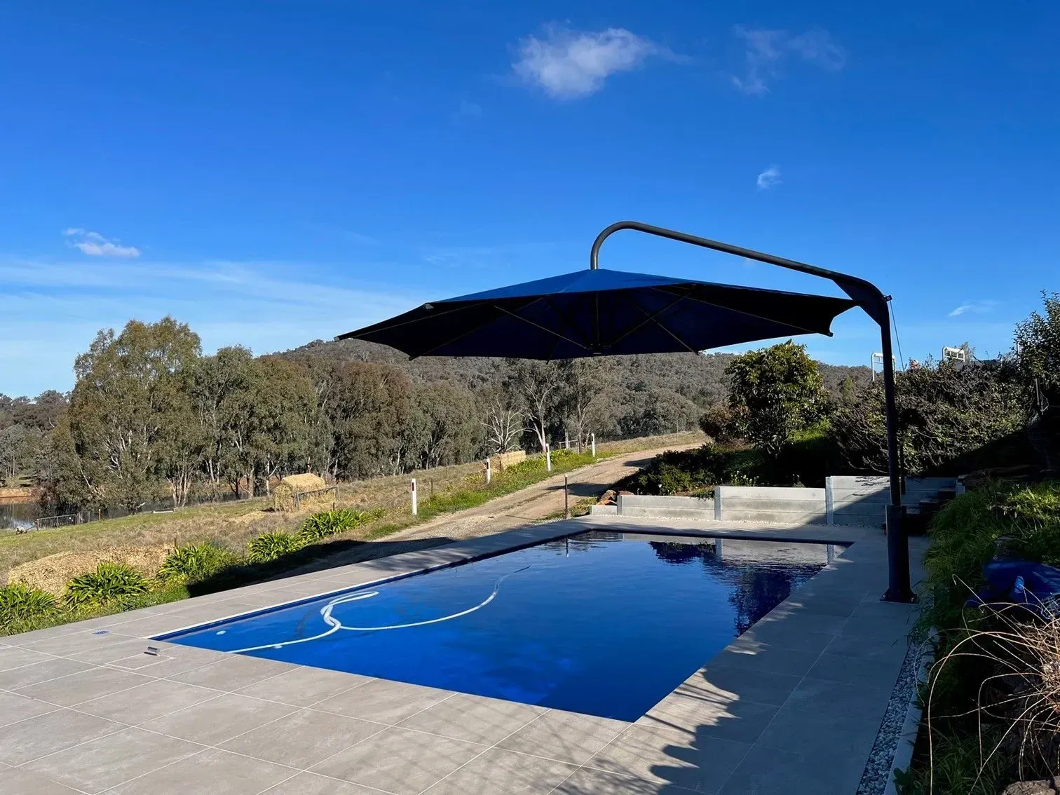 Blue Pool With a Cantilever Umbrella, Overlooking — The Gazebo and Shade Centre in Jindera, NSW