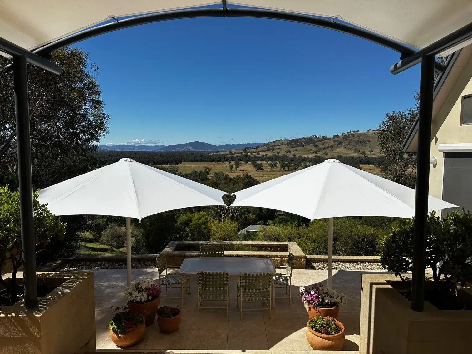 Two White Umbrellas Over Patio Furniture — The Gazebo and Shade Centre in Jindera, NSW