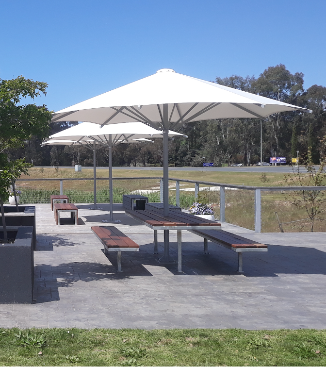 Outdoor picnic area with white umbrellas, benches, and tables on a sunny day — The Gazebo and Shade Centre in Corowa, NSW