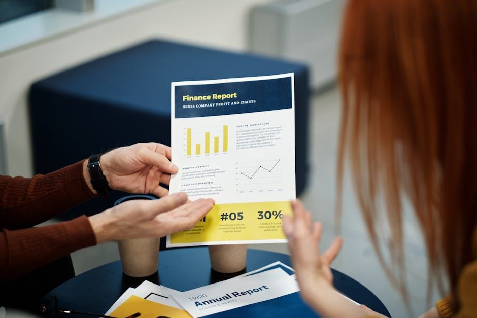 Handen die een financieel rapport met grafieken en percentages vasthouden in een kantooromgeving.