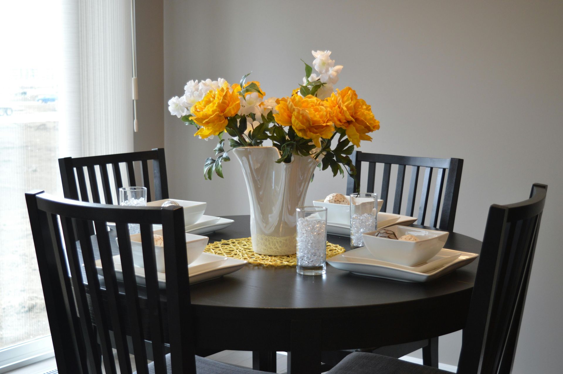 A wooden table with wicker chairs around it