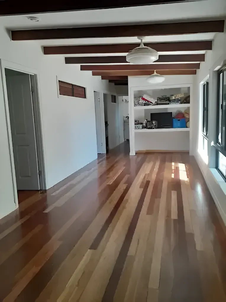 A Large Empty Room With Wooden Floors And White Walls — Dale Dow Floor Sanding In Kirwan, QLD