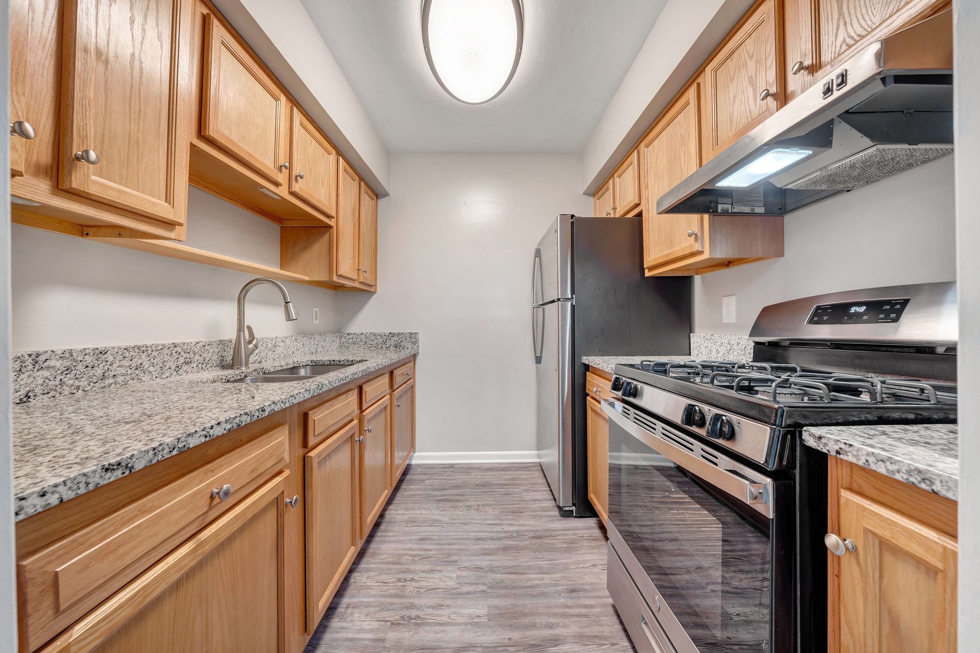 A kitchen with stainless steel appliances and wooden cabinets.