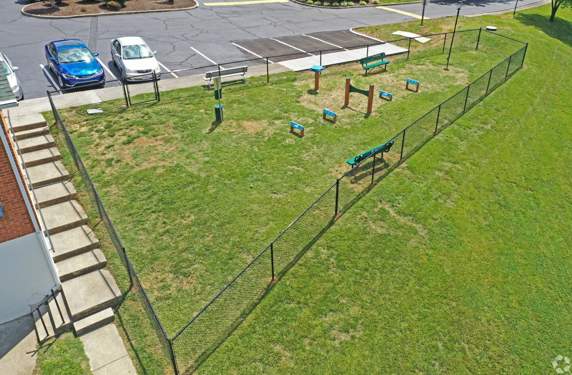 An aerial view of a dog park with a fence and benches.