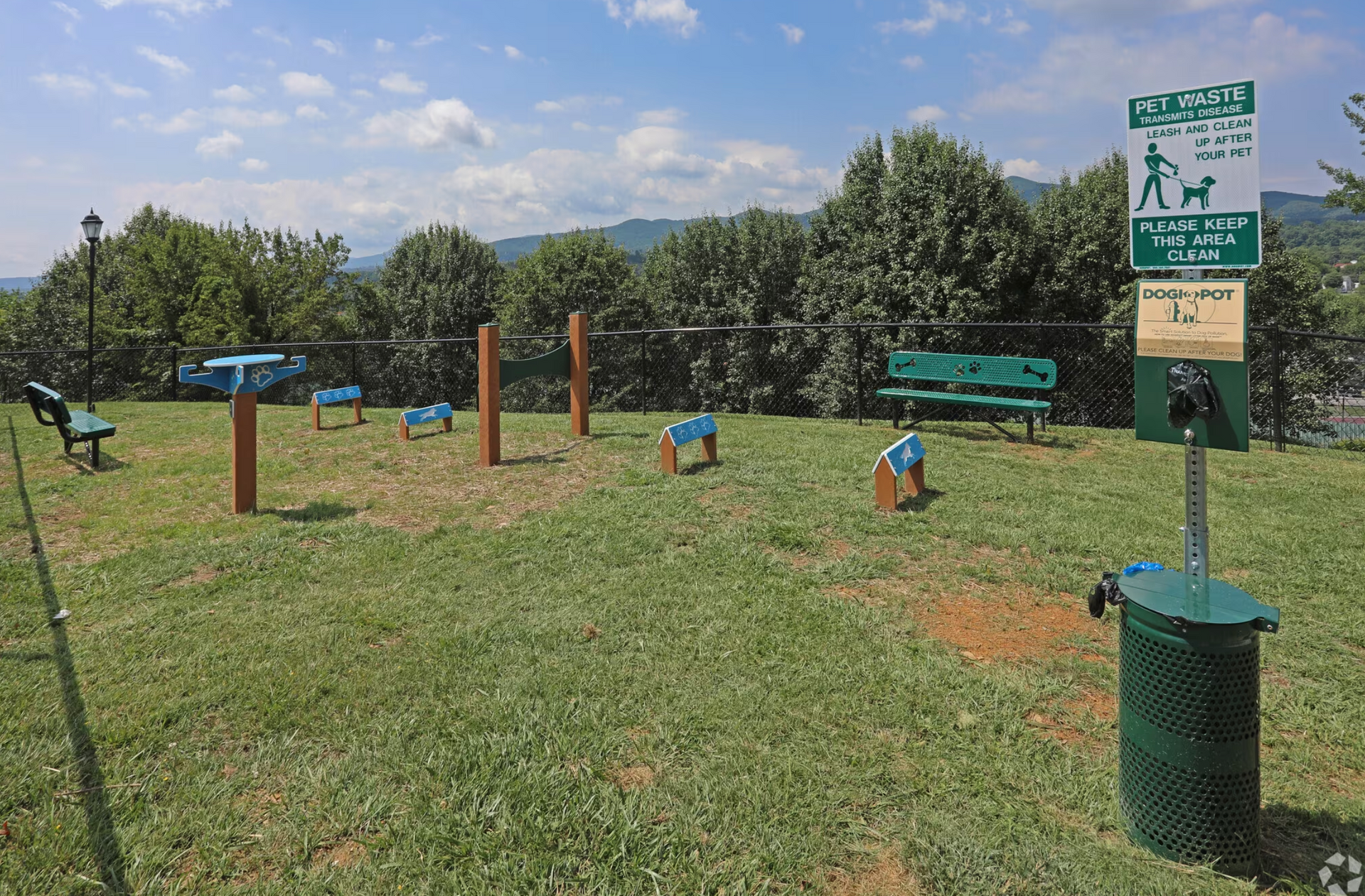 A dog park with benches and a sign that says do not walk on the grass